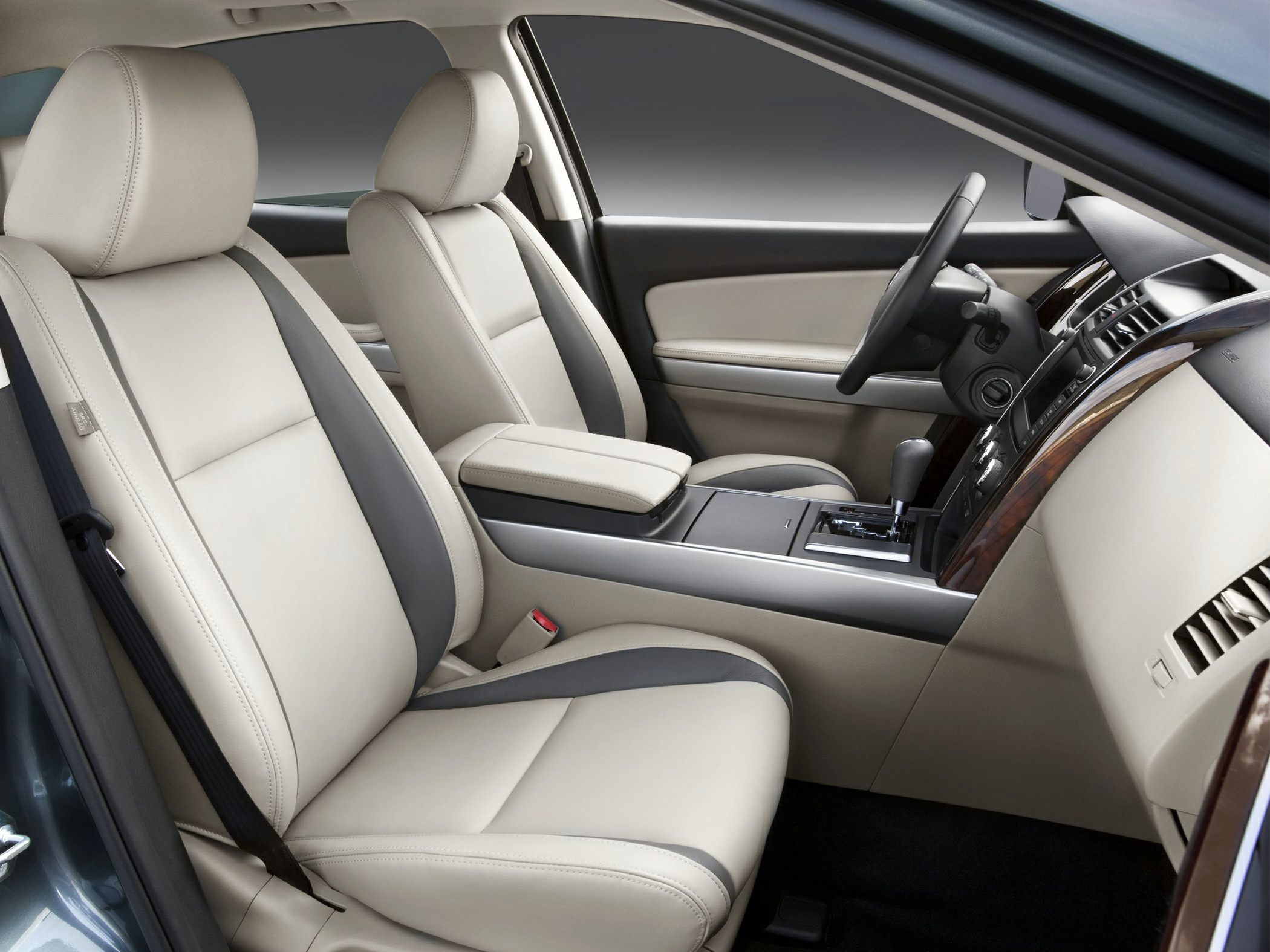 Beige leather front seats with wood-accented dashboard and central console