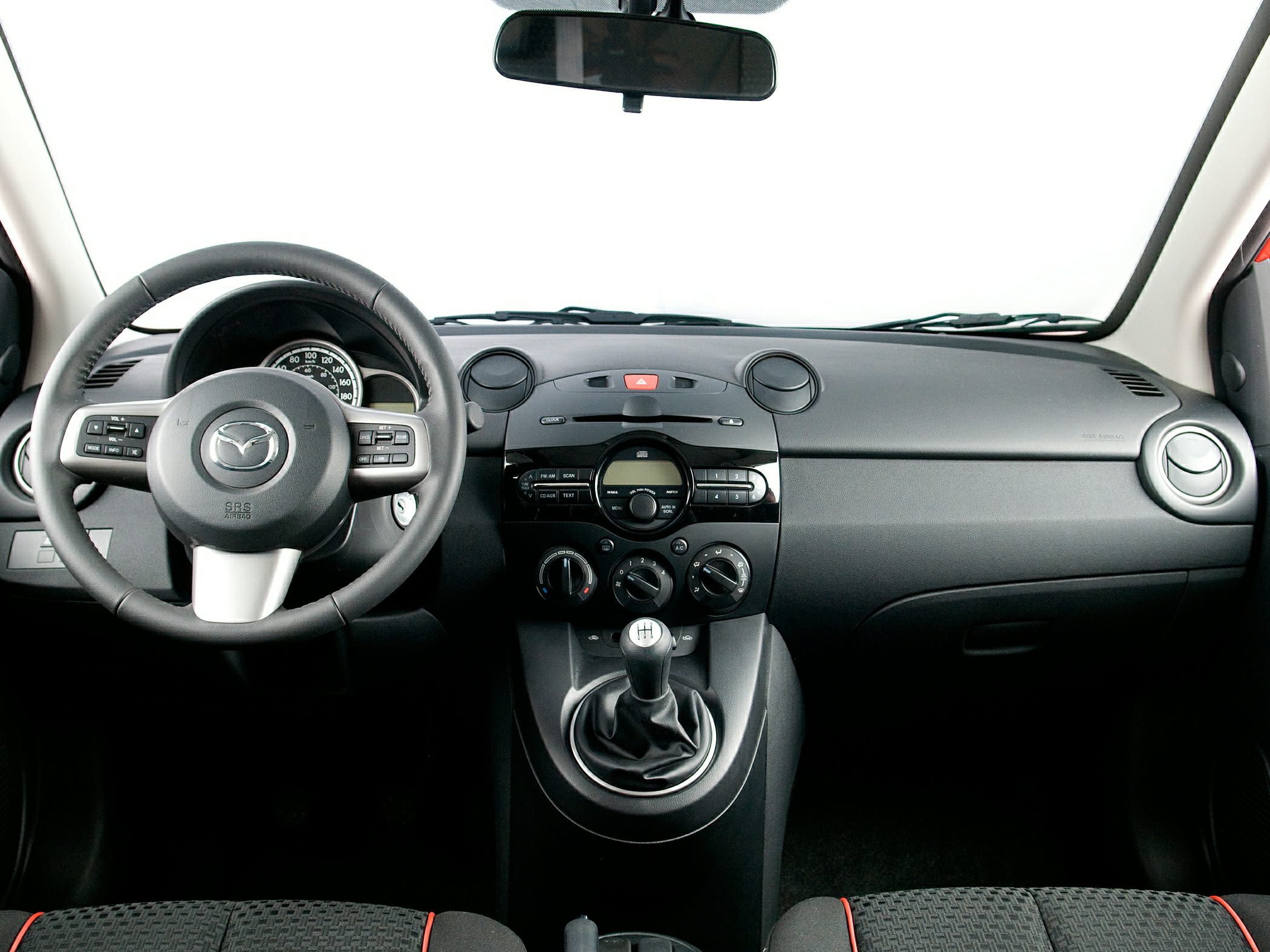 Manual gear stick and steering wheel with controls in car interior
