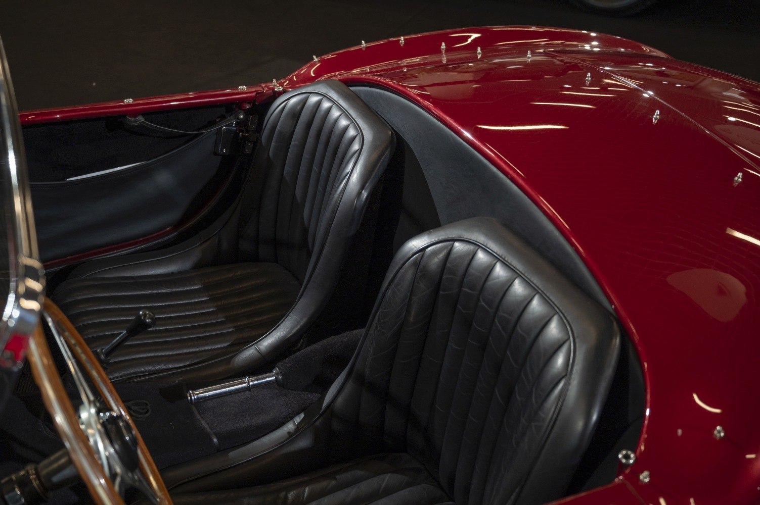 Black leather bucket seats with glossy red interior paneling