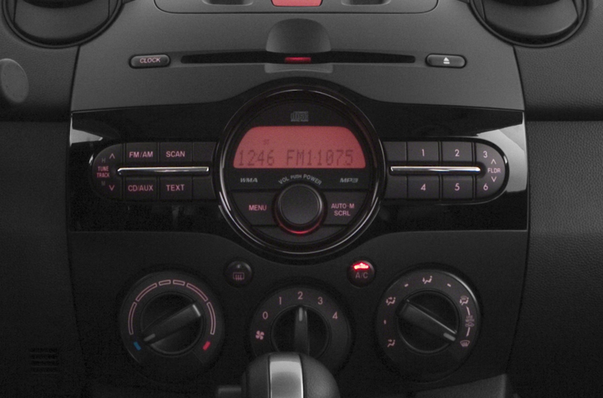 Central radio and climate control panel with illuminated display and knobs