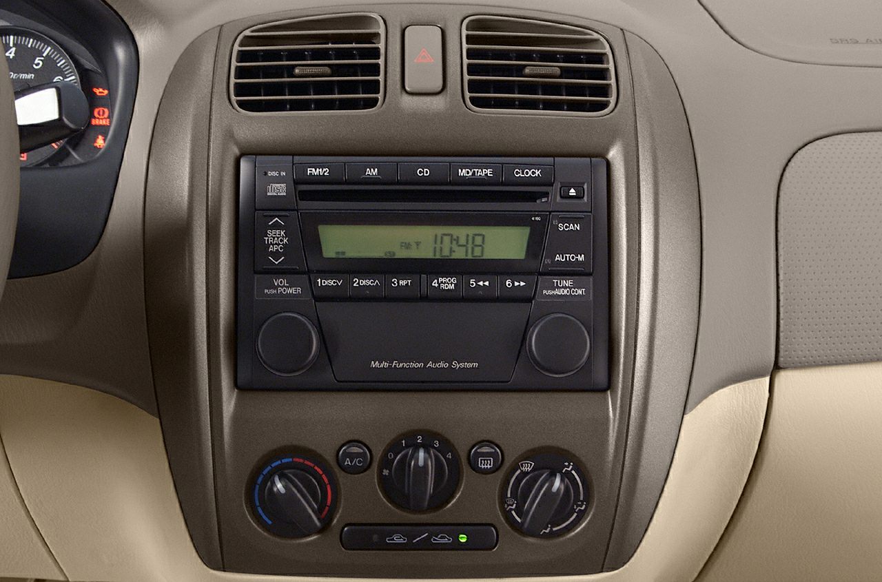 Dashboard audio system and climate control knobs in beige interior