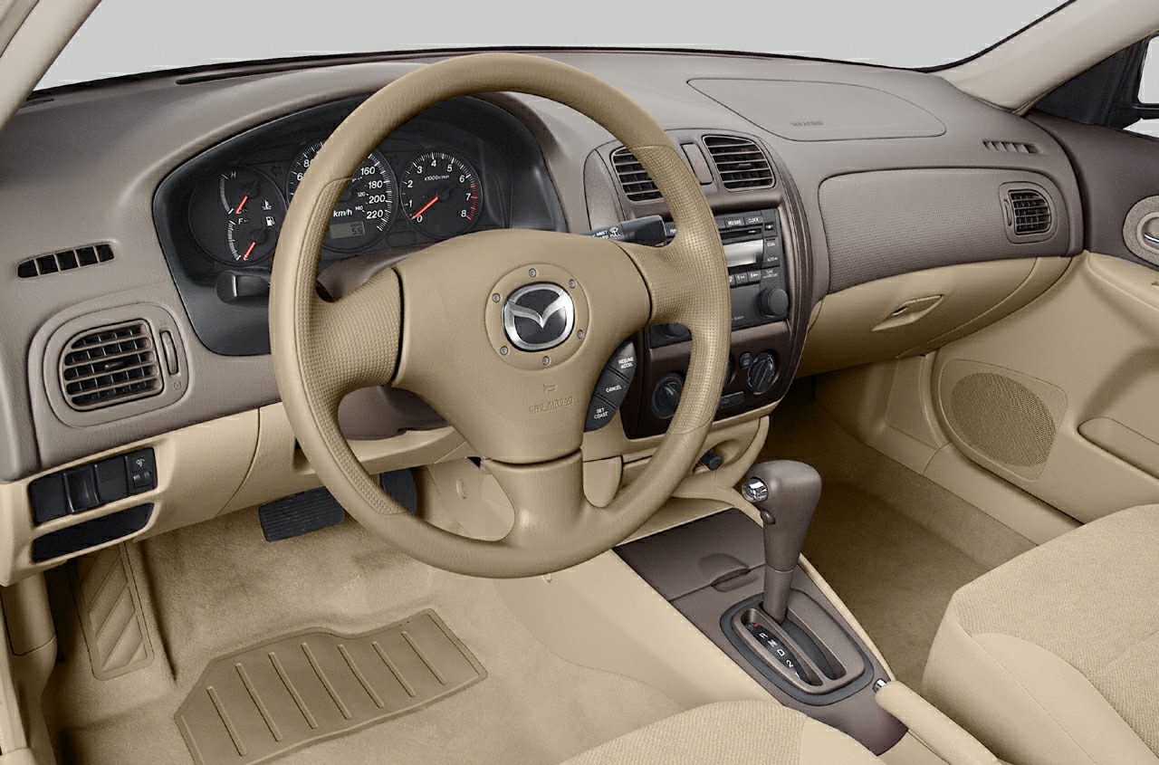 Beige interior with steering wheel, dashboard, and automatic gear shift