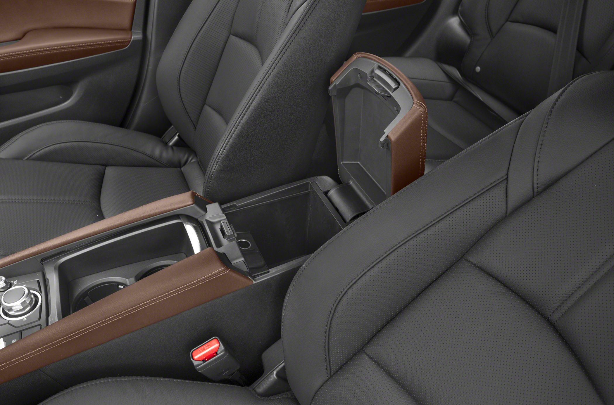 Open center console storage and cup holders in black leather seats interior.
