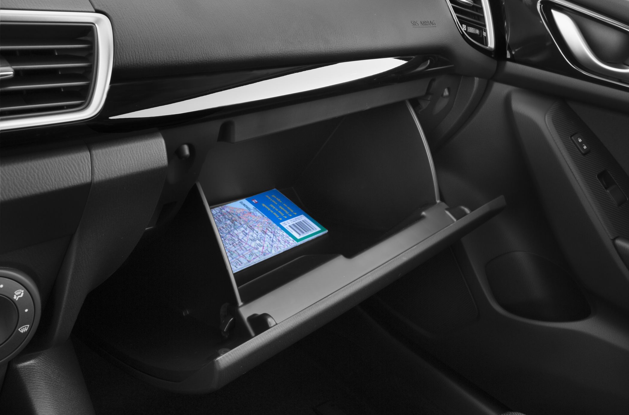 Open glove compartment with book inside, detailed interior storage view