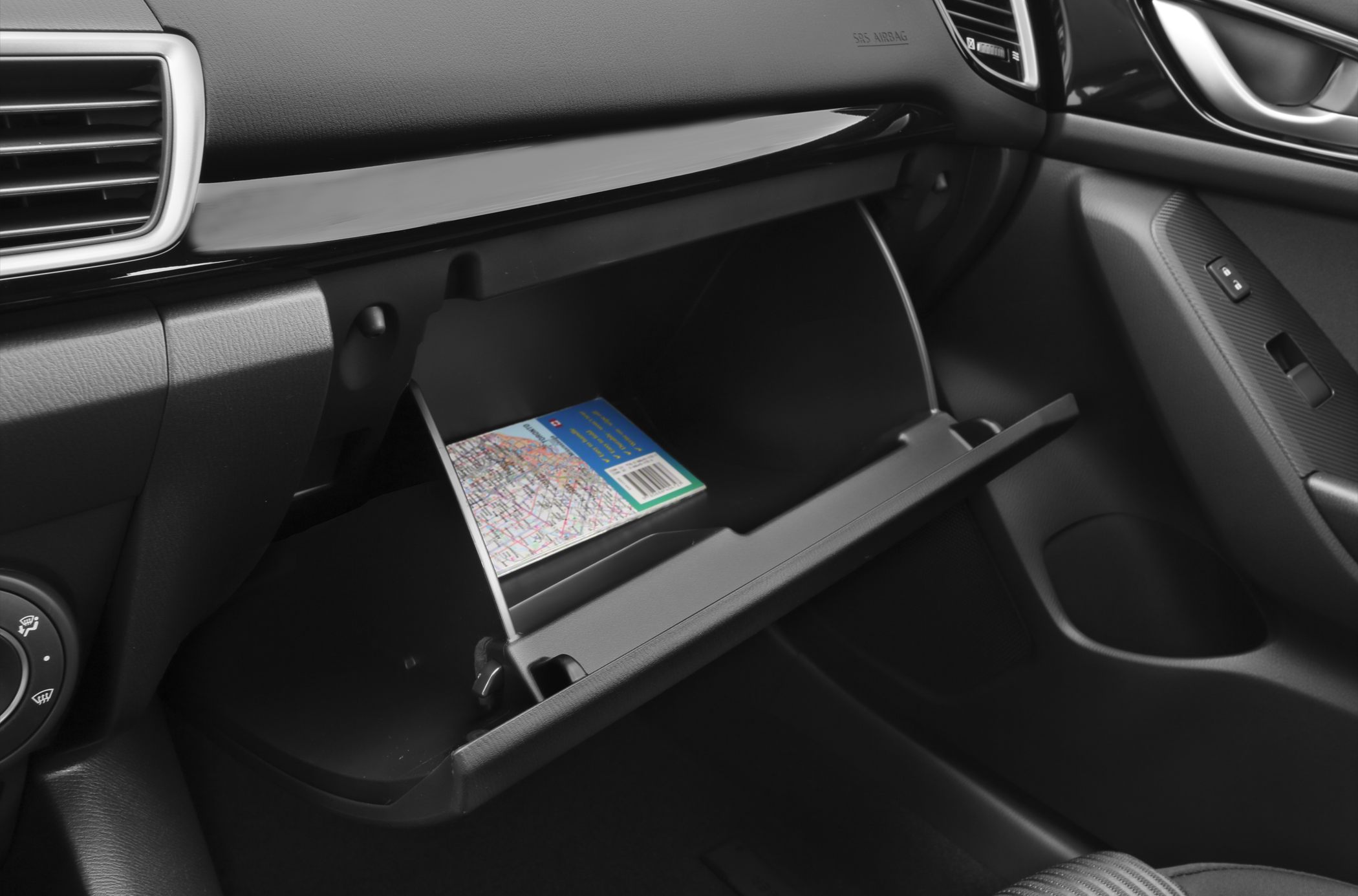 Open glove box with visible map inside vehicle interior