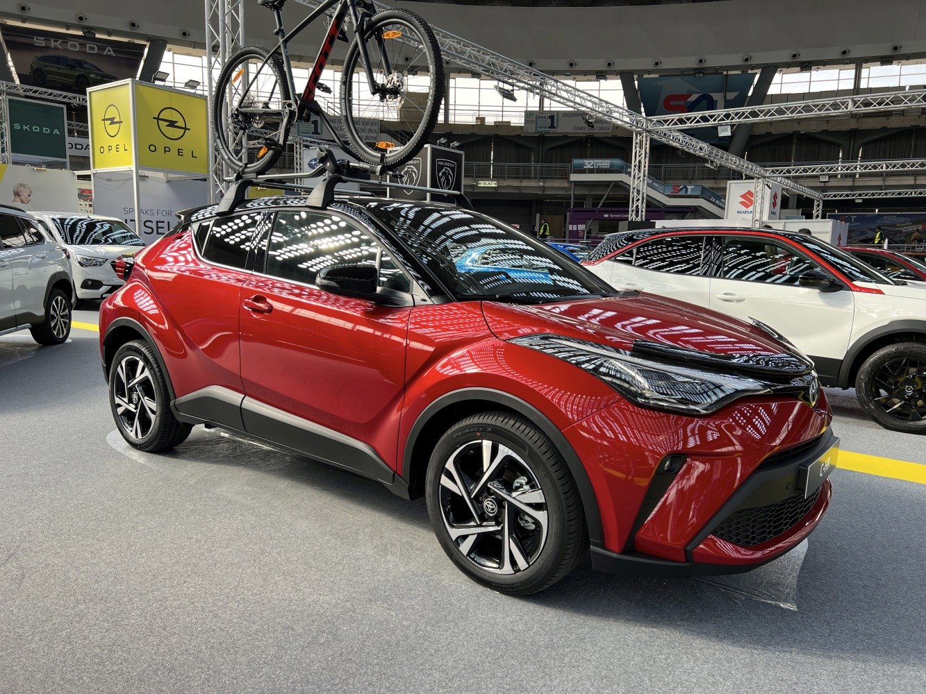 Red SUV with sporty headlights and roof bike carrier