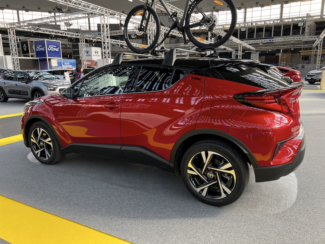 Side profile of a modern compact SUV with roof bicycle rack and distinctive rear lights