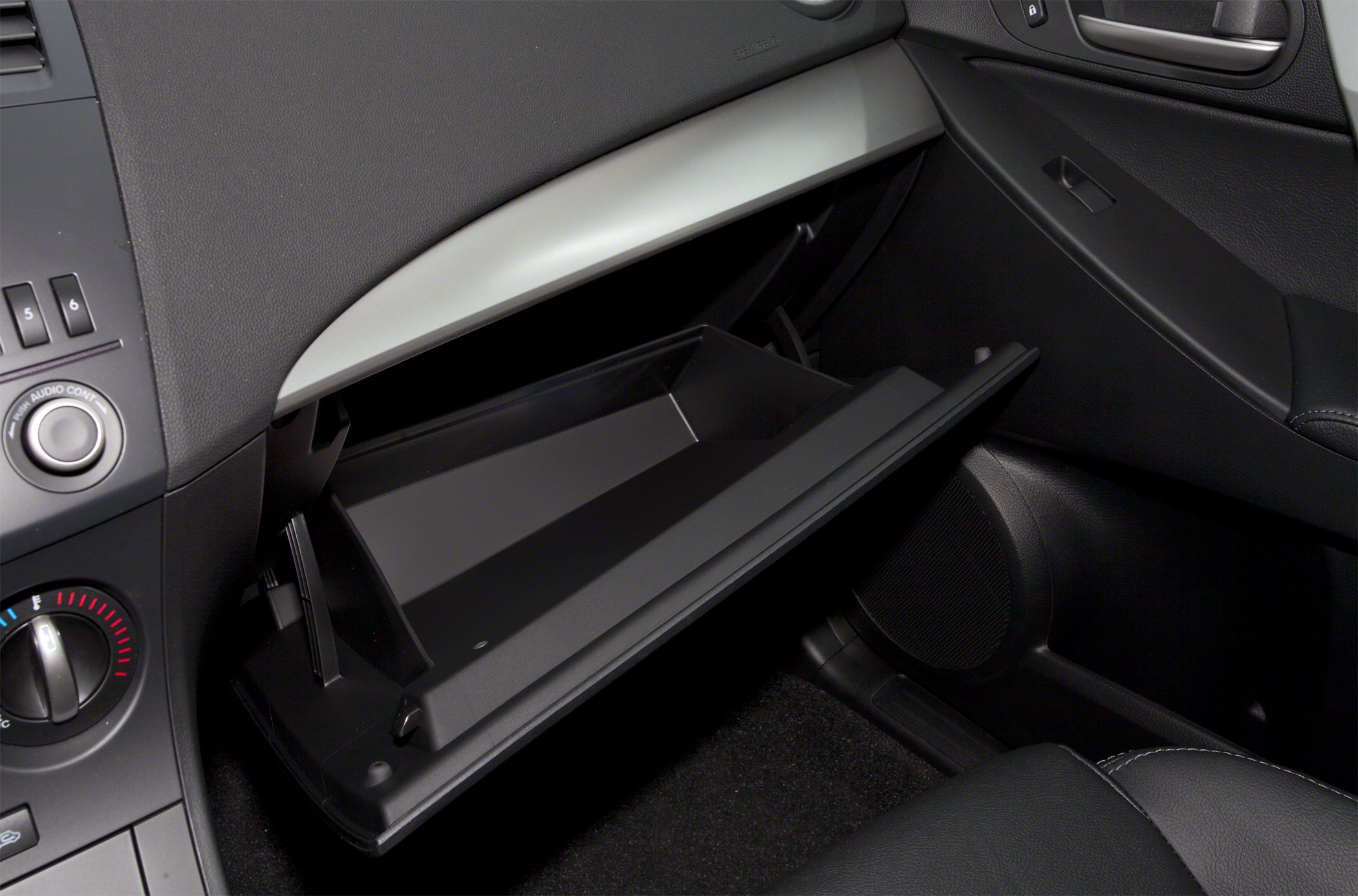 Open glove compartment and dashboard controls inside vehicle