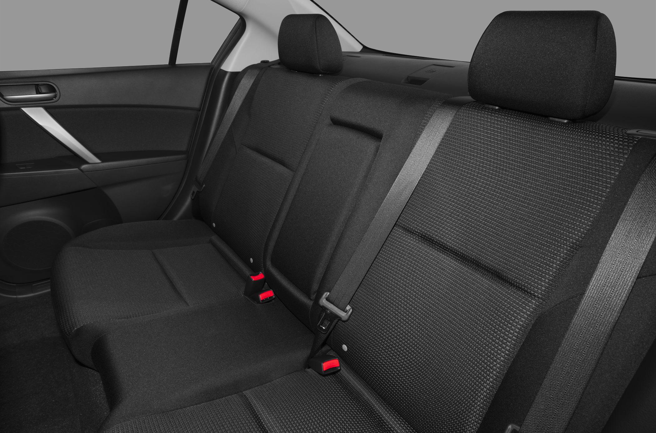 Fabric rear seats with headrests and seat belts in a sedan interior