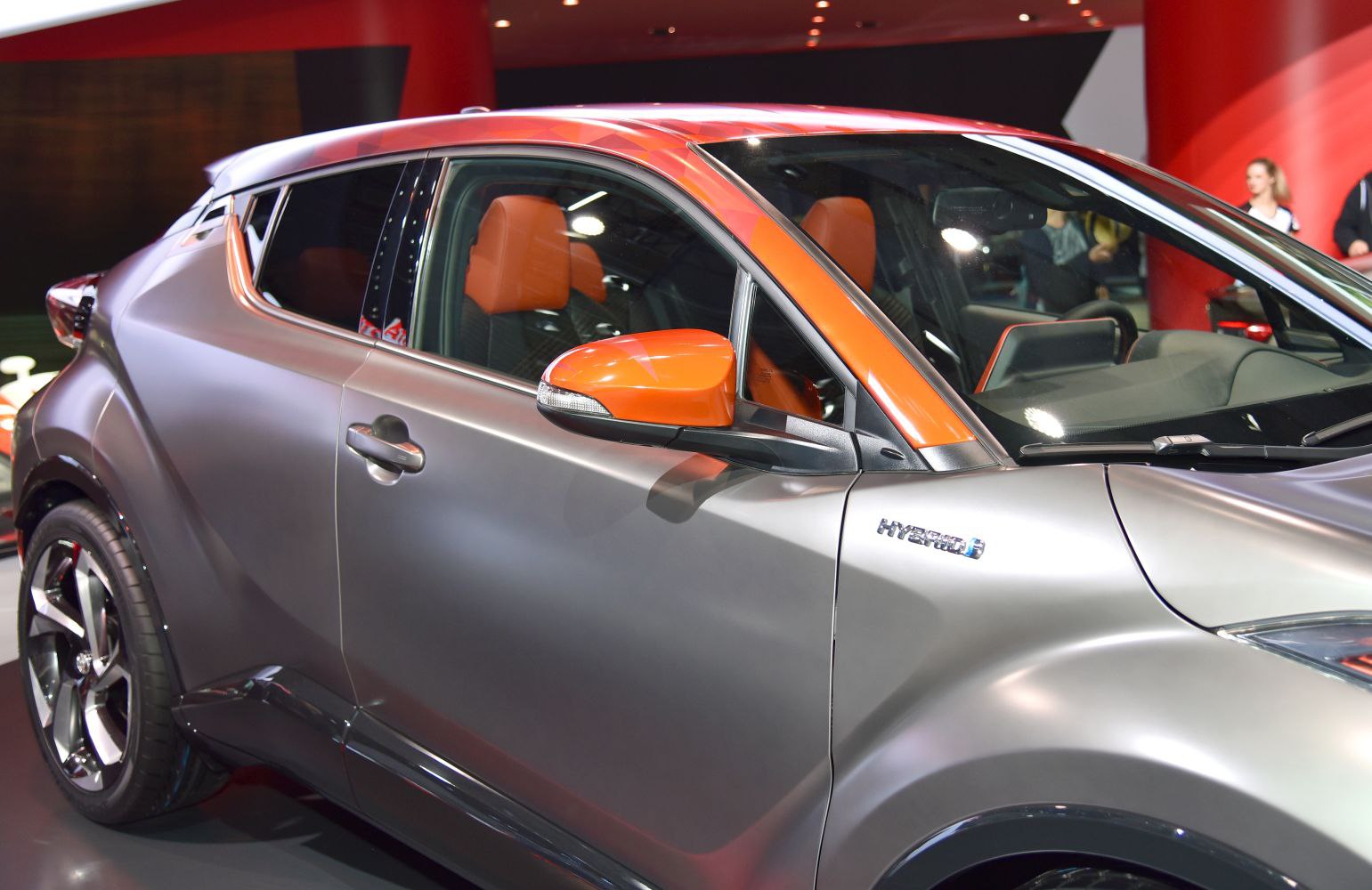 Sleek side profile and orange-accented interior details of a hybrid vehicle