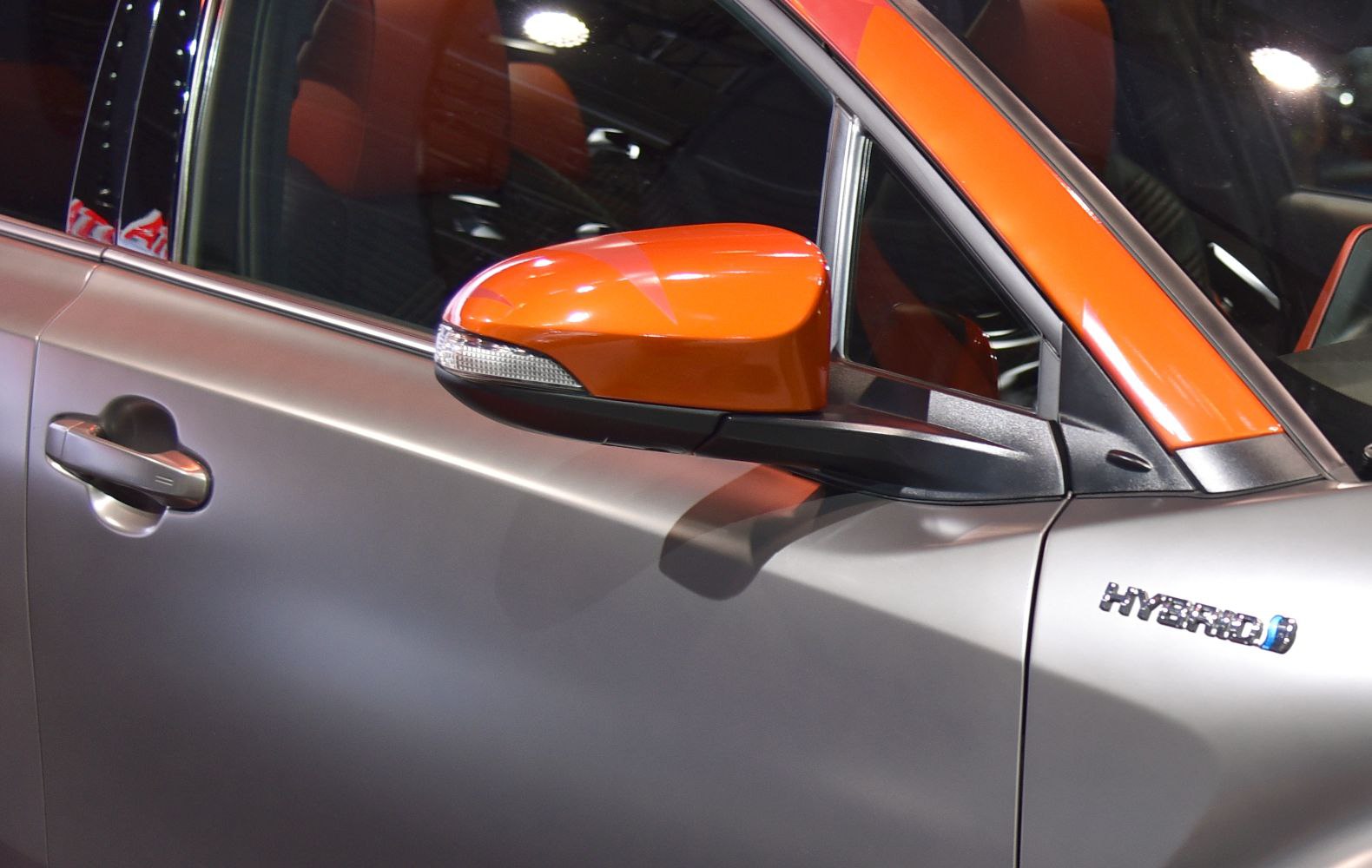 Close-up of side mirror and hybrid badge on car door