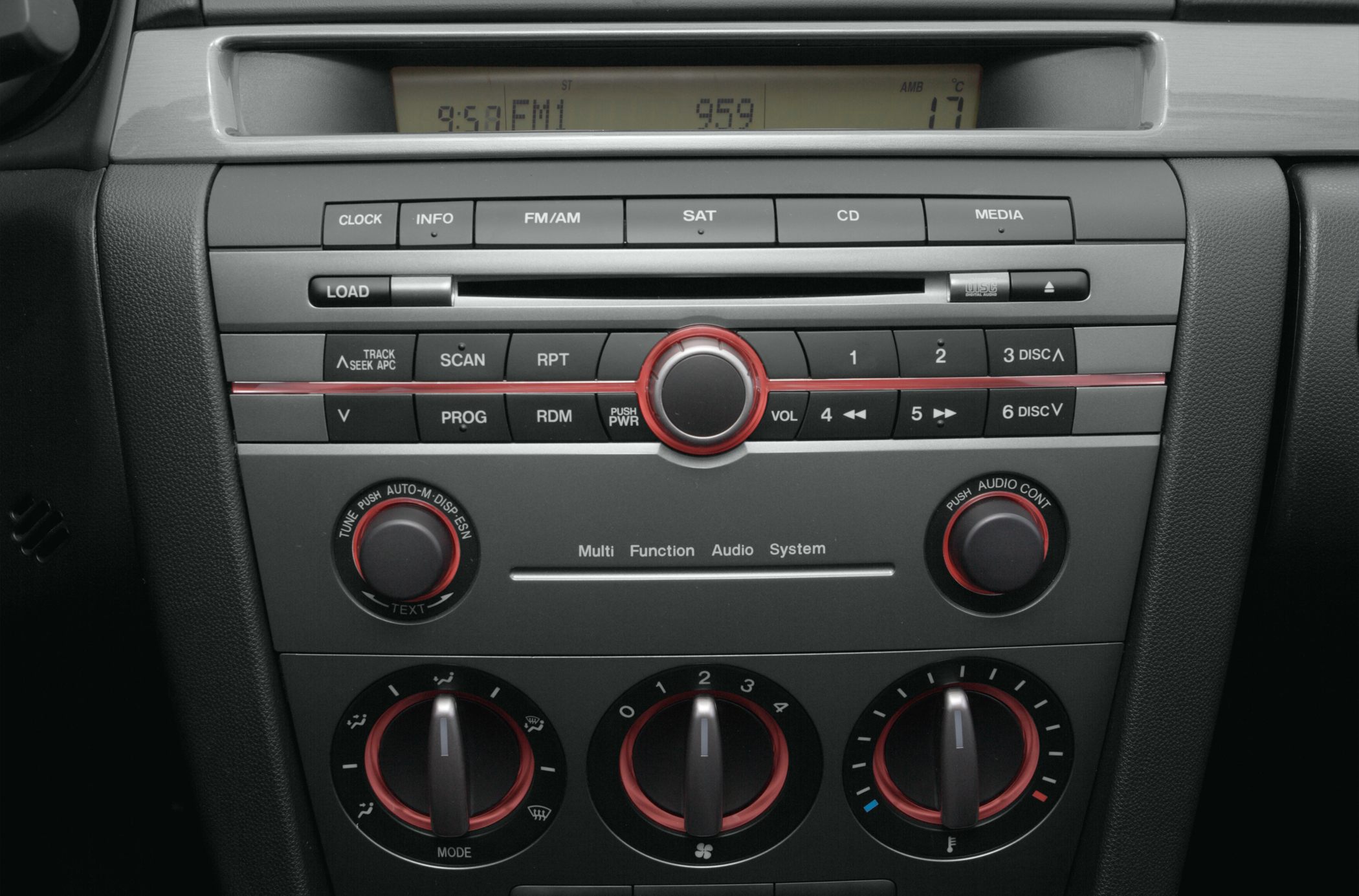 Close-up of car audio system and climate control dials with red detailing