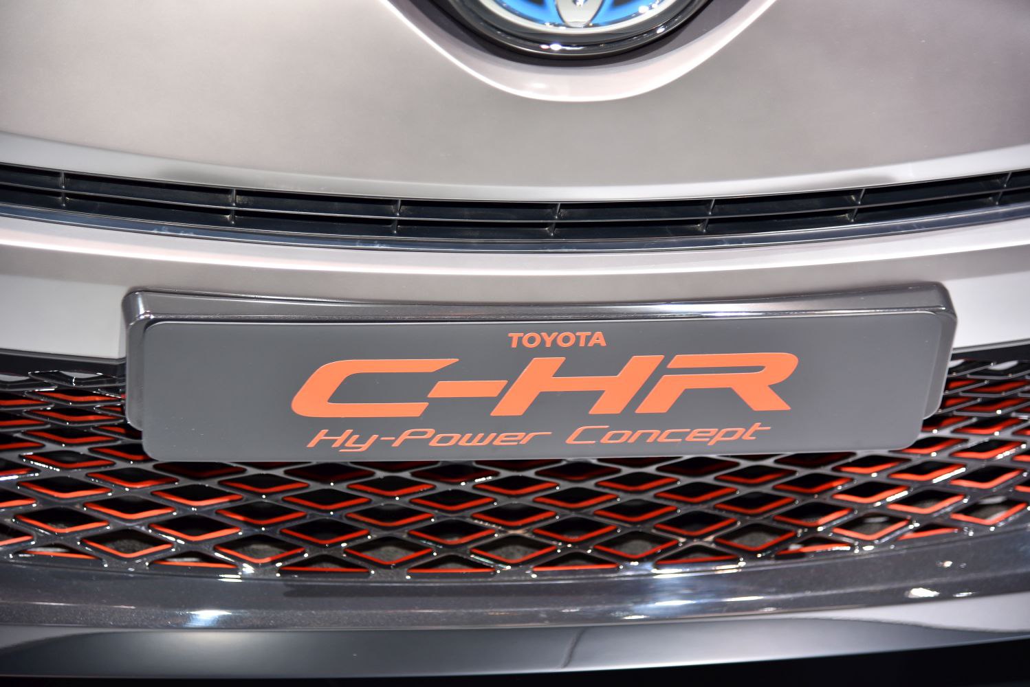 Close-up of front grille and badge with orange details