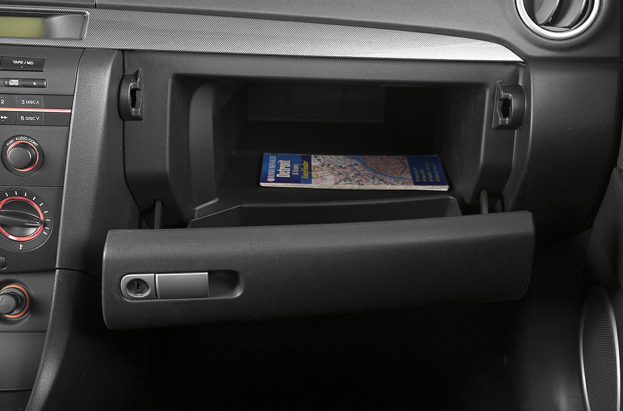 Open glove compartment with storage space and part of dashboard controls