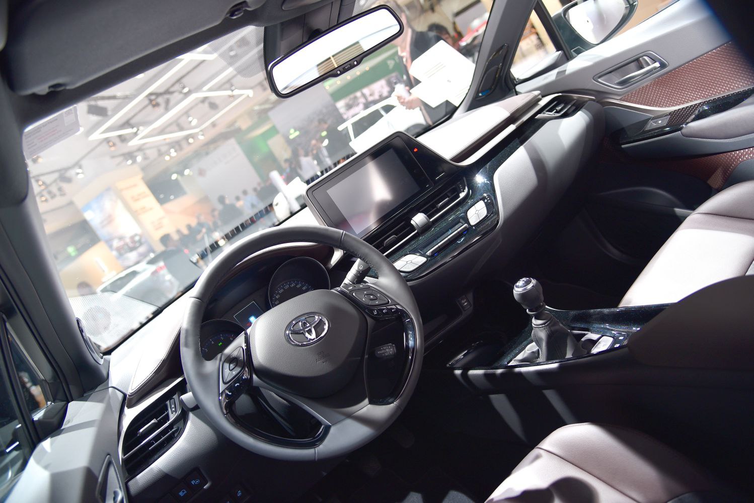 Interior view showing dashboard, steering wheel, touchscreen, and gear shift.