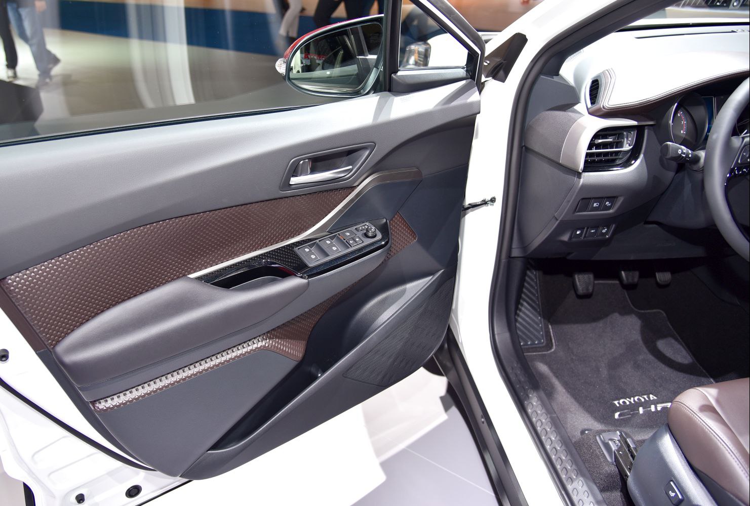 Interior door panel with control buttons and front cabin including pedals and floor mat