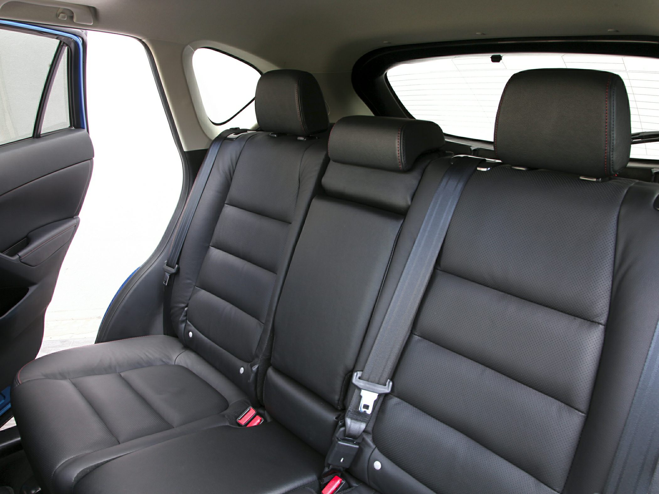 Rear seat interior with black leather upholstery, headrests and seat belts