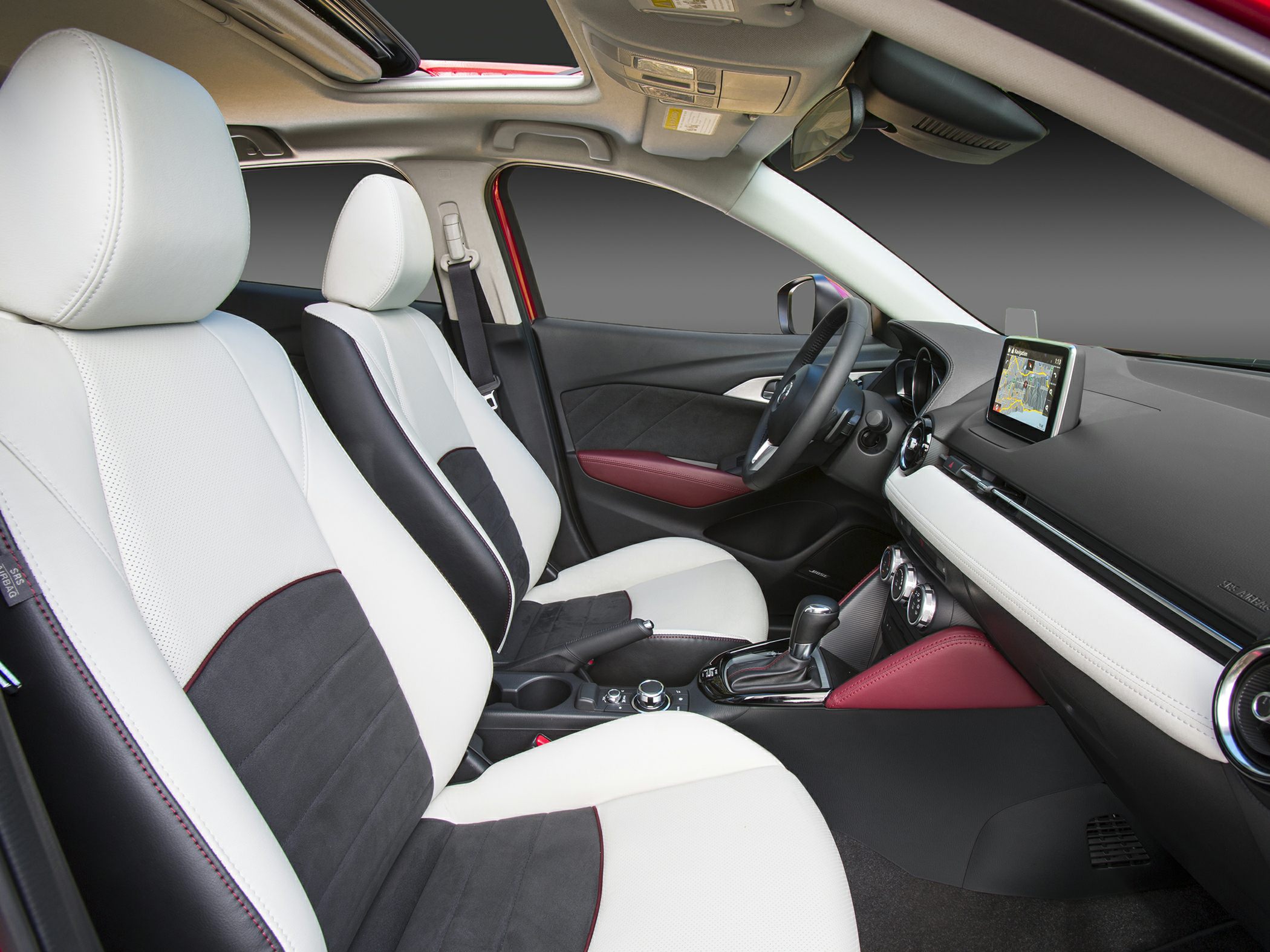 White and black front seats with panoramic sunroof and infotainment screen
