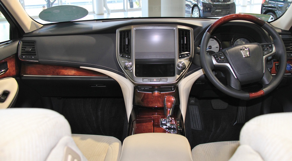 Wood-trimmed dashboard and steering wheel with central touchscreen in luxurious interior
