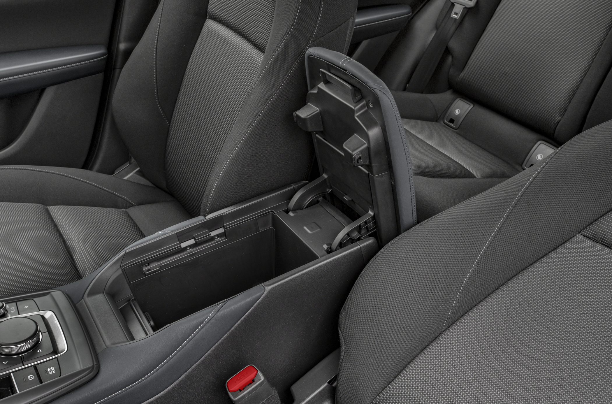 Open center console storage between front seats with fabric upholstery.