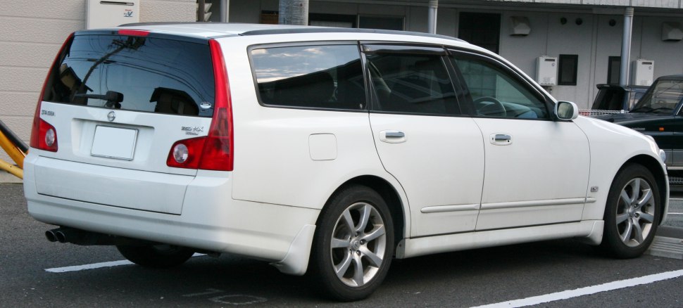 Rear side view of a sleek station wagon with distinctive vertical taillights and alloy wheels.