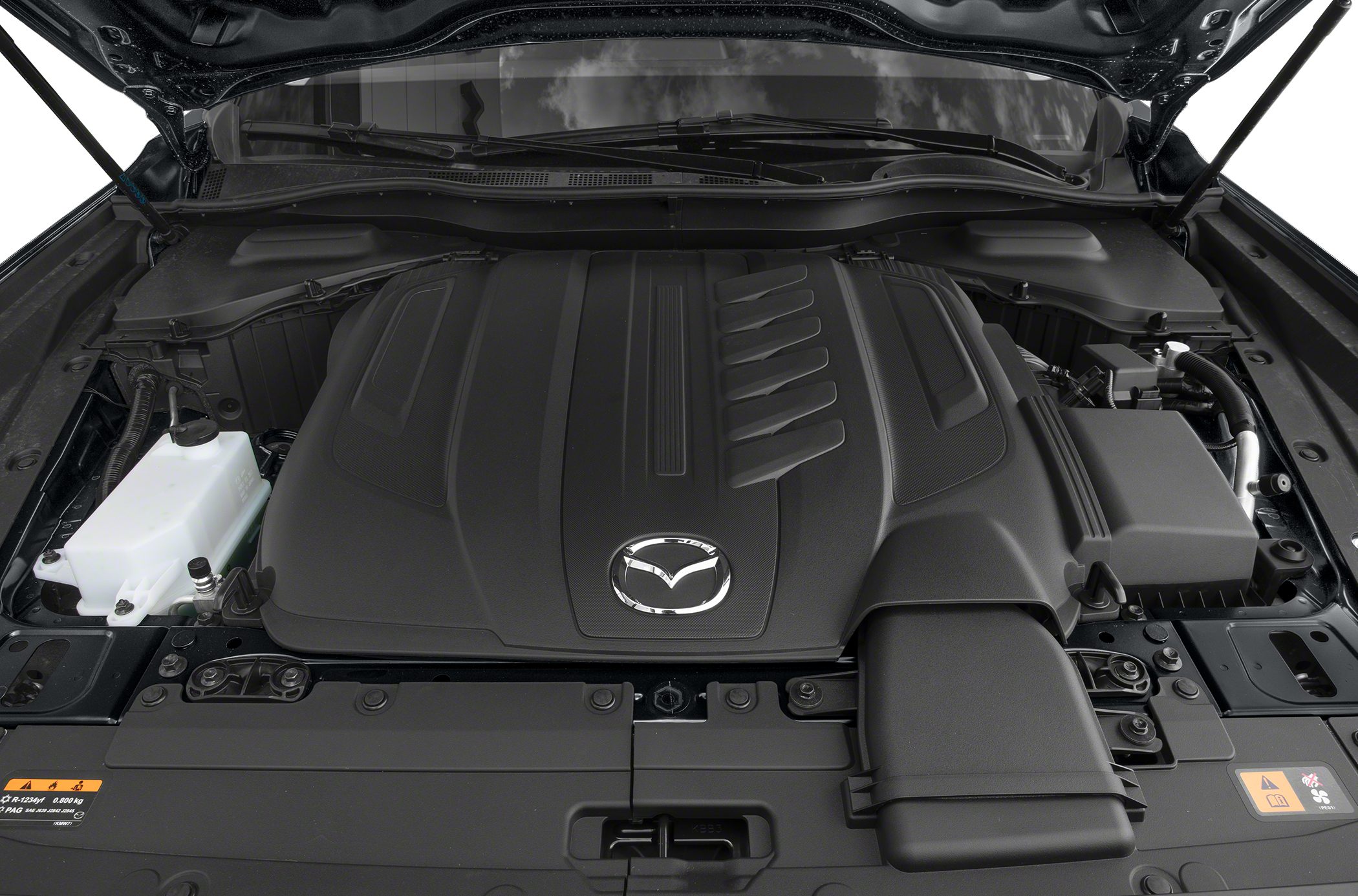 Covered engine compartment with Mazda emblem and engine components