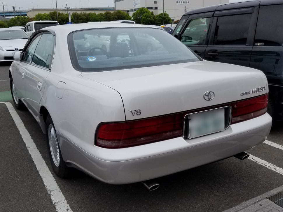Rear view showcasing V8 badge and wraparound taillight design