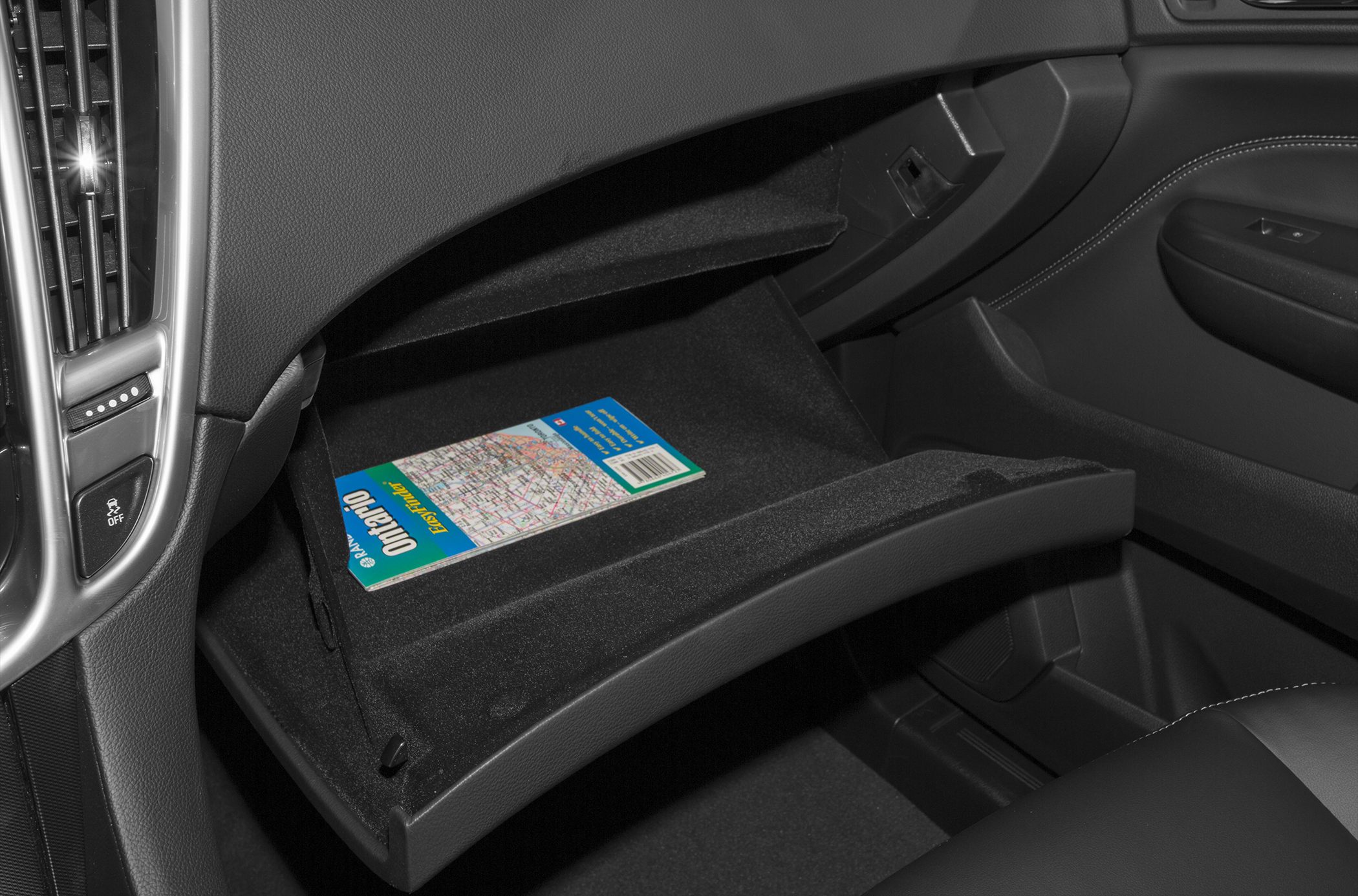Open glove box with a map inside in car interior
