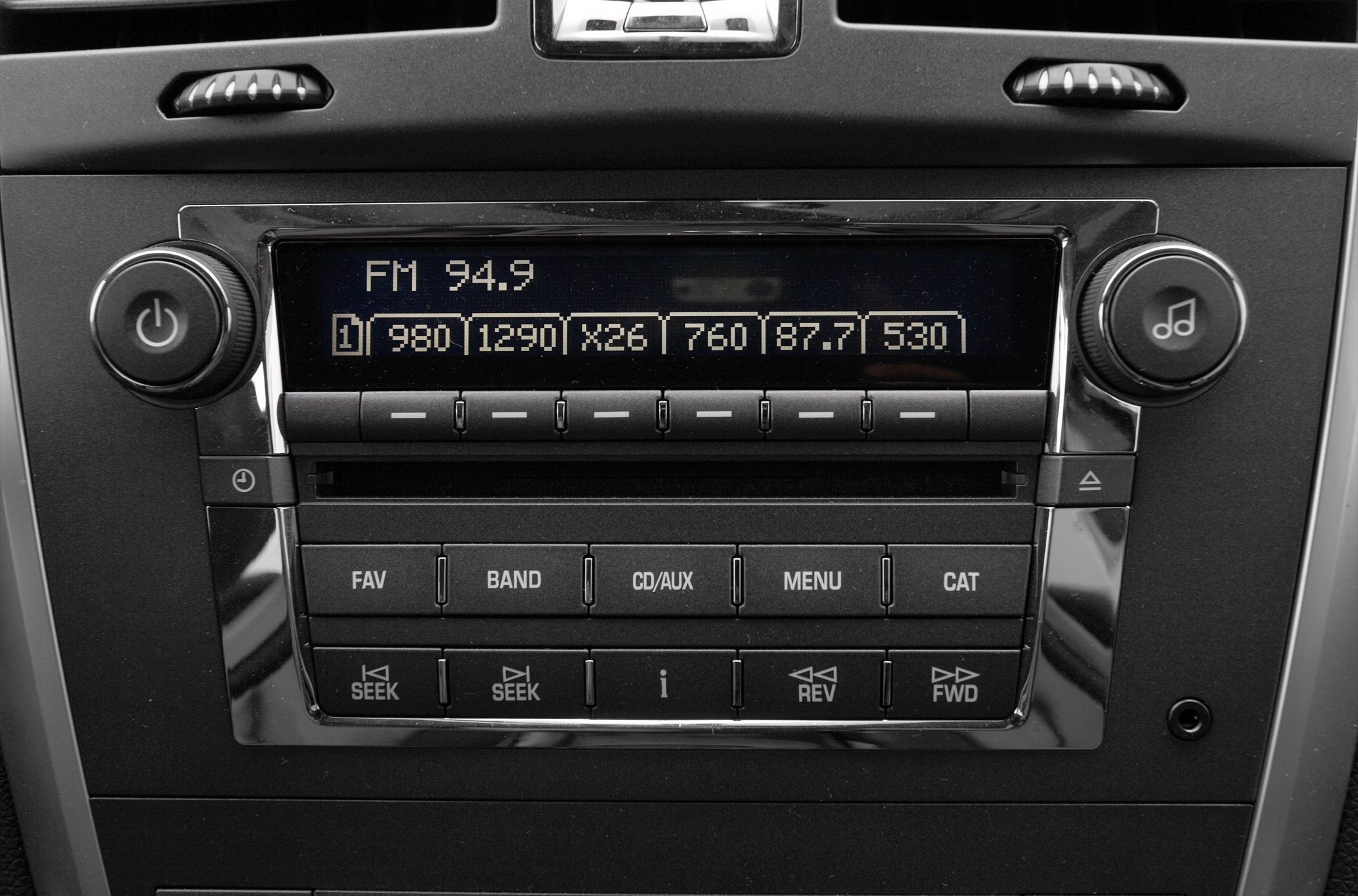 FM radio display and control buttons on a car audio system.