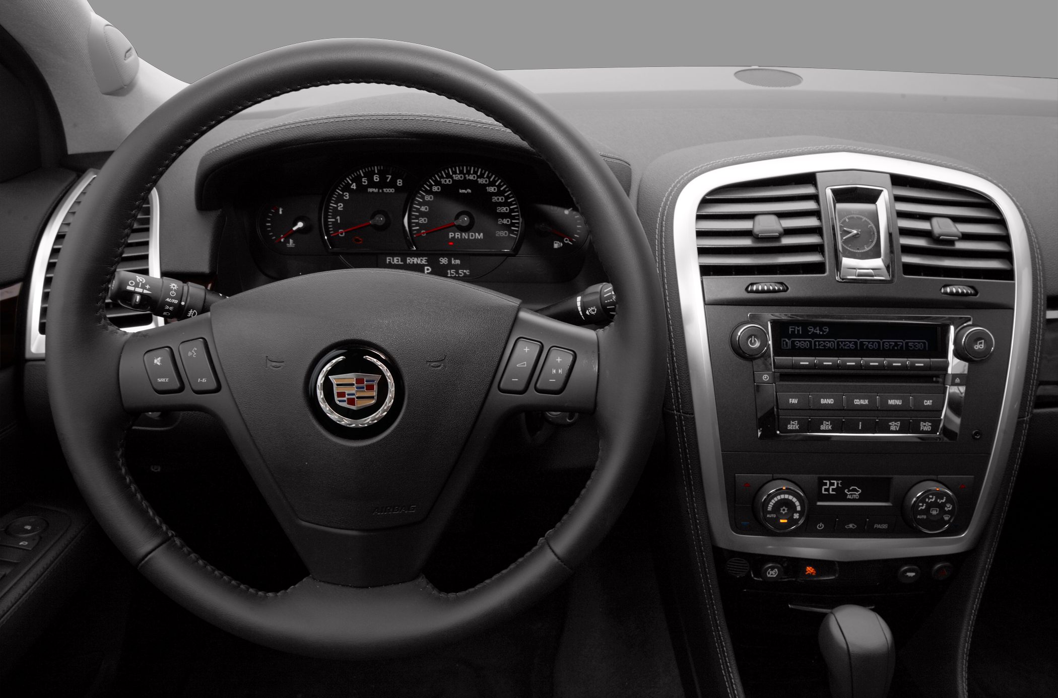 Steering wheel with controls and dashboard instruments with center console in car interior