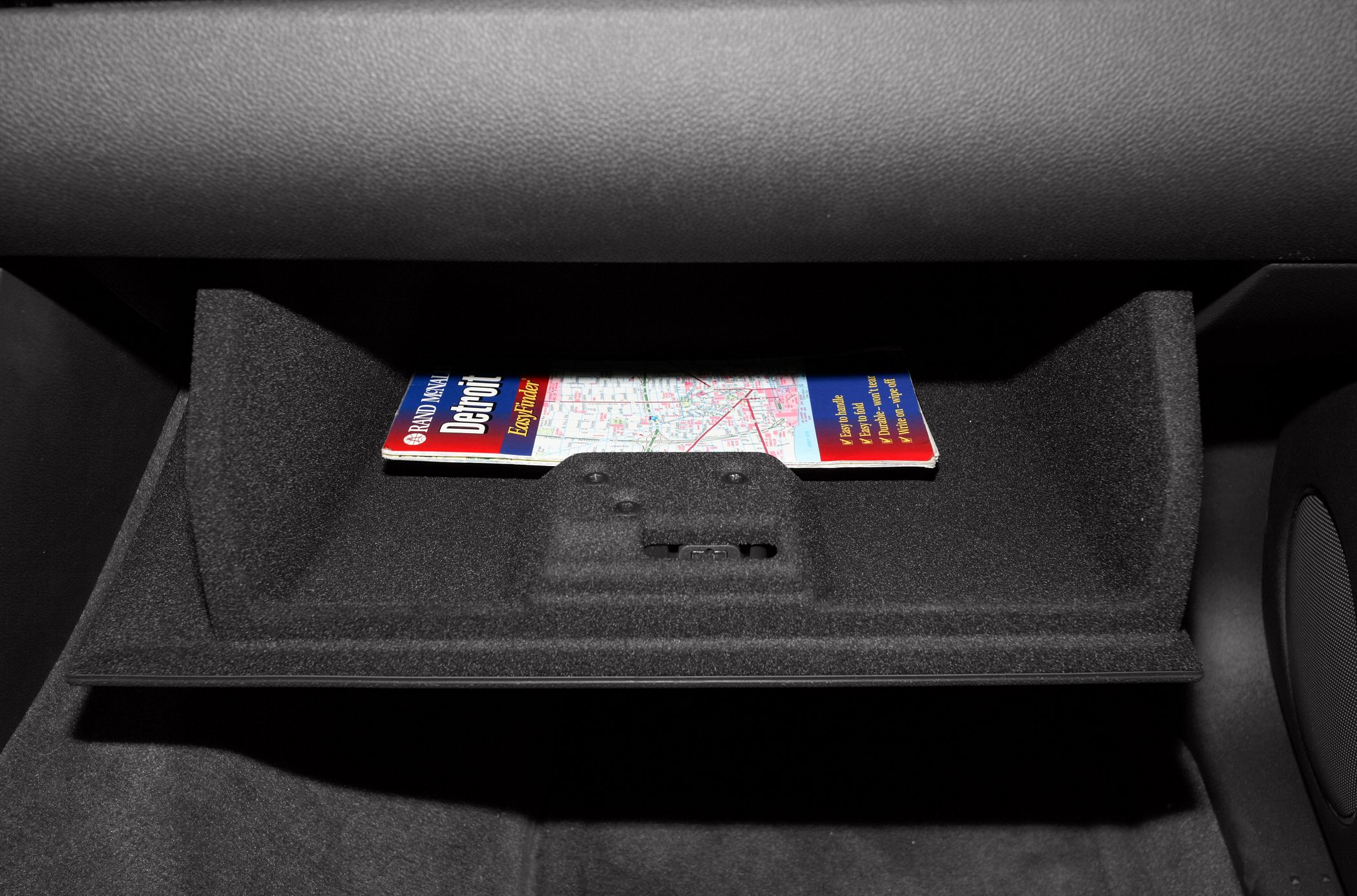 Glove compartment with map storage and textured interior lining