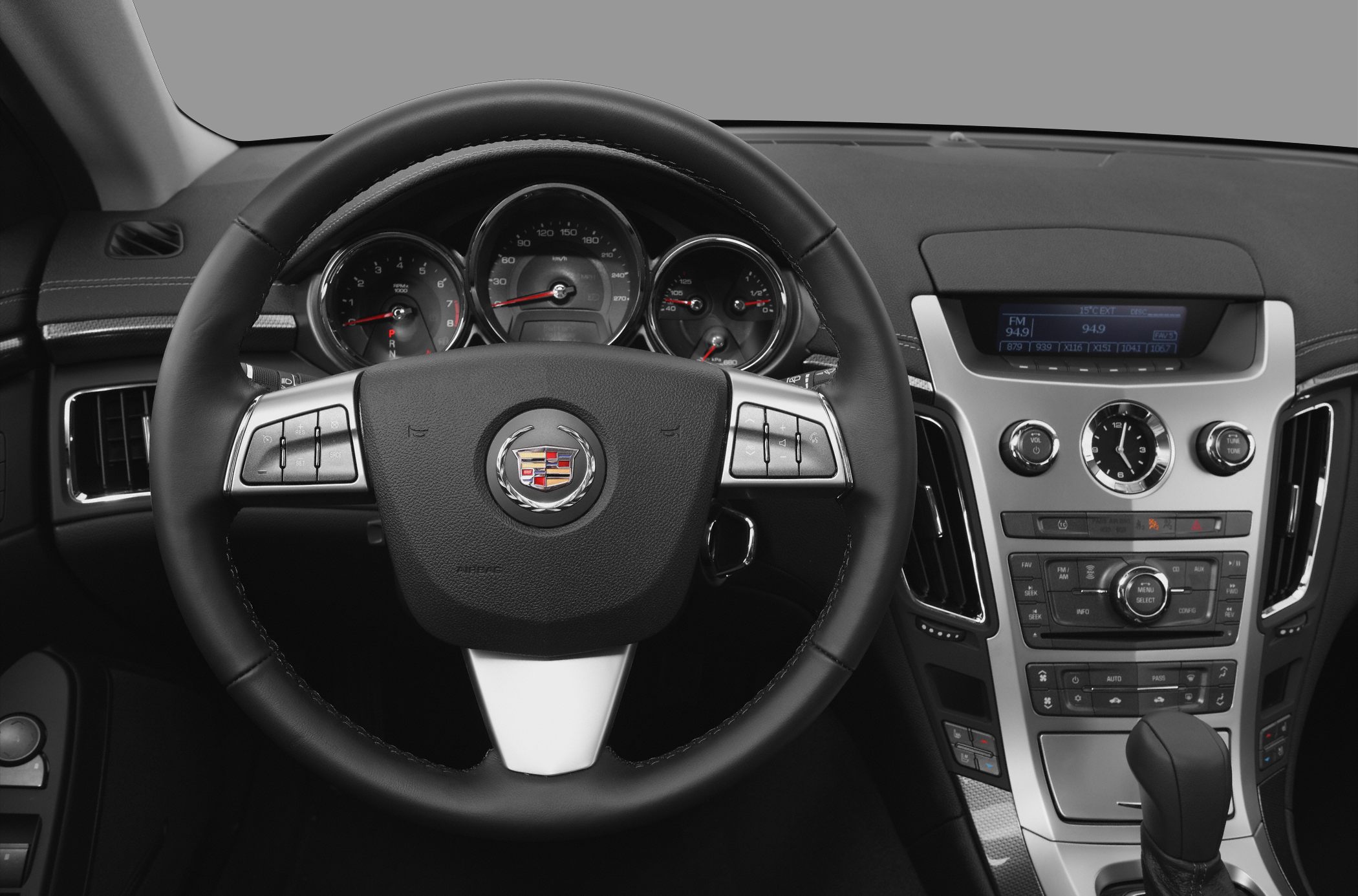 Steering wheel, dashboard gauges, analog clock, center console controls