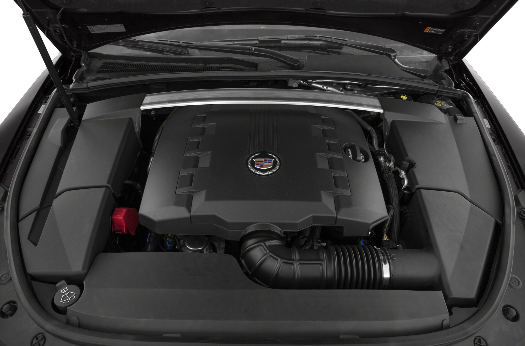 Engine bay with a large engine cover and intake hose featuring a Cadillac emblem