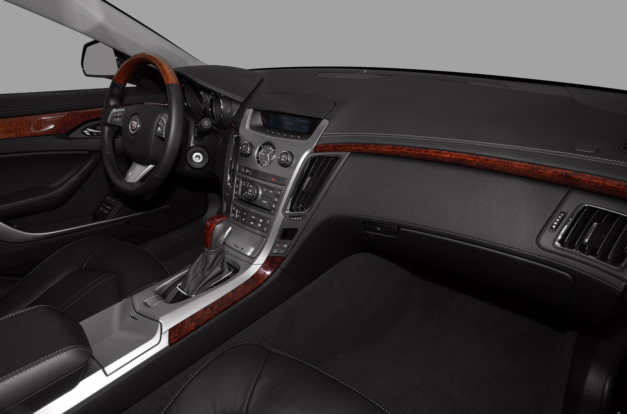 Wood-trimmed steering wheel and dashboard, center console with controls.