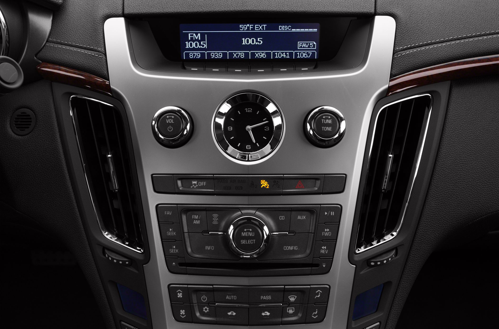 Center console with analog clock, audio controls, and climate buttons