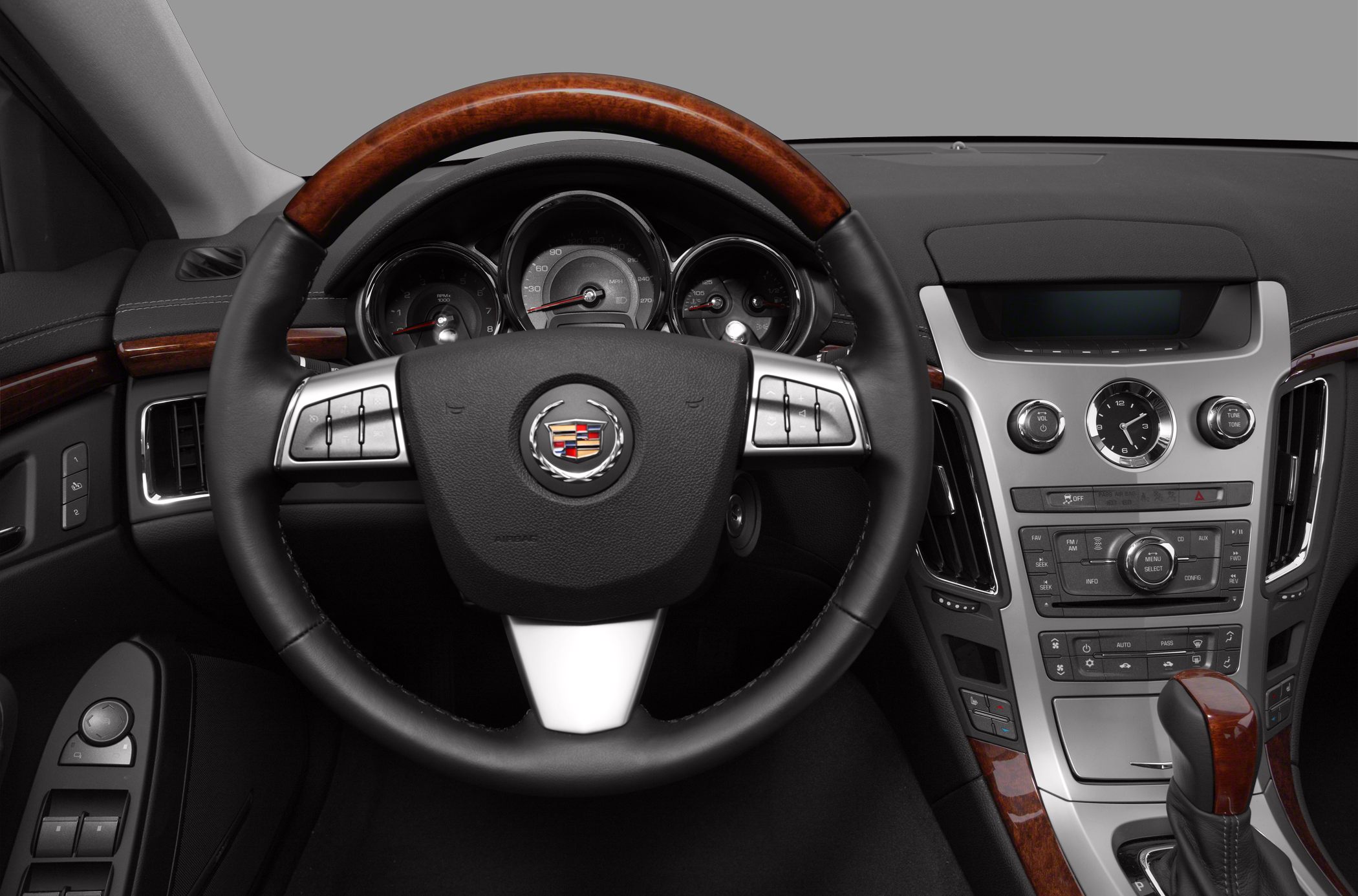 Steering wheel with wood trim, analog gauges, center console with clock and controls