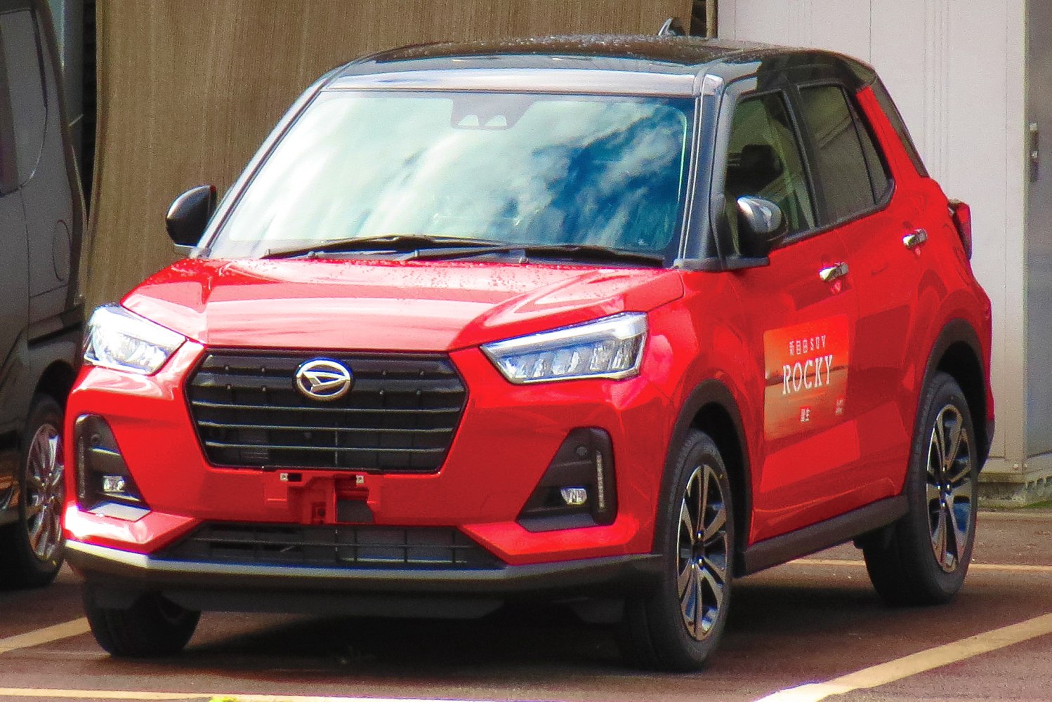 Red compact SUV front view with LED headlights and black grille
