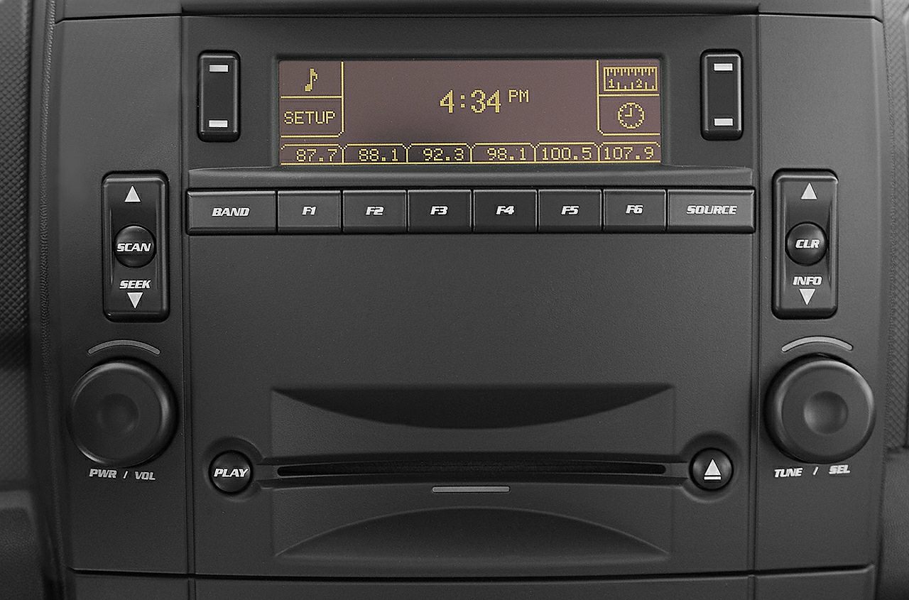 Digital car radio and audio control panel with multifunction buttons and display.