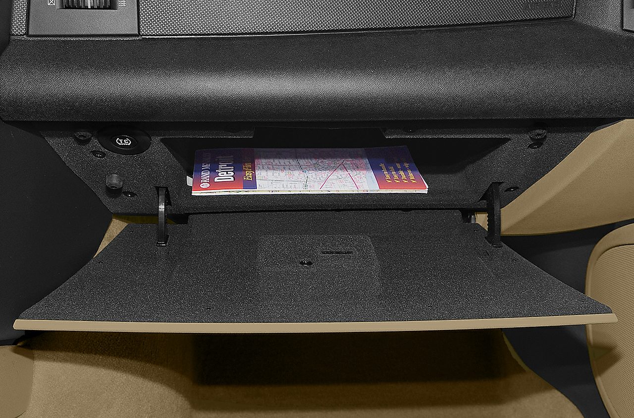 Open glove box with map inside in vehicle interior