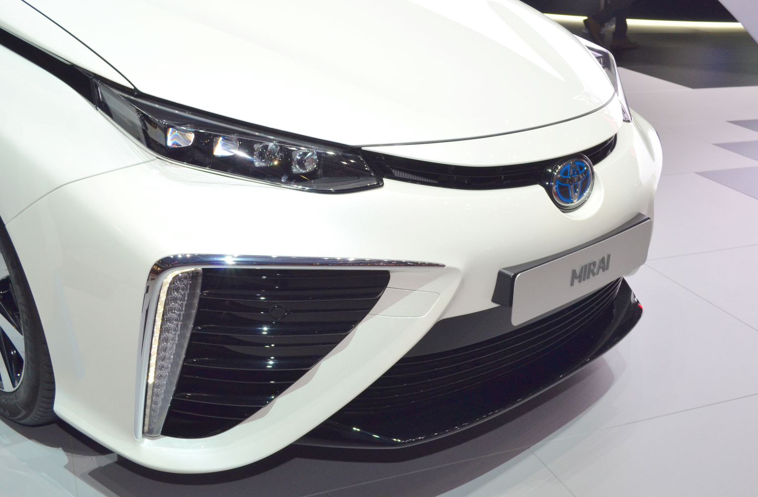 Close-up of front headlights and grille with LED lights on a sleek white front.