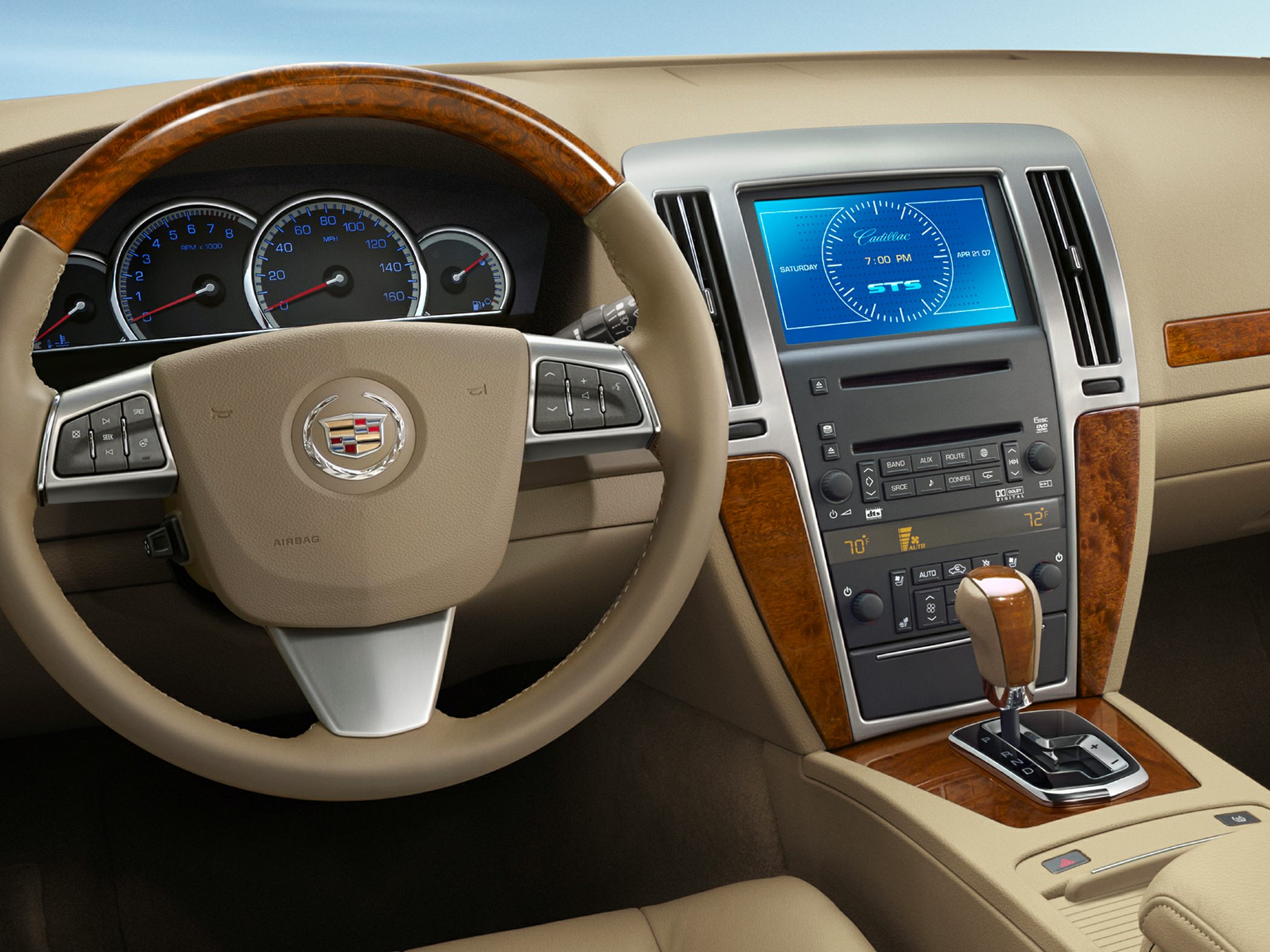 Wood-trimmed steering wheel and digital infotainment display in beige dashboard