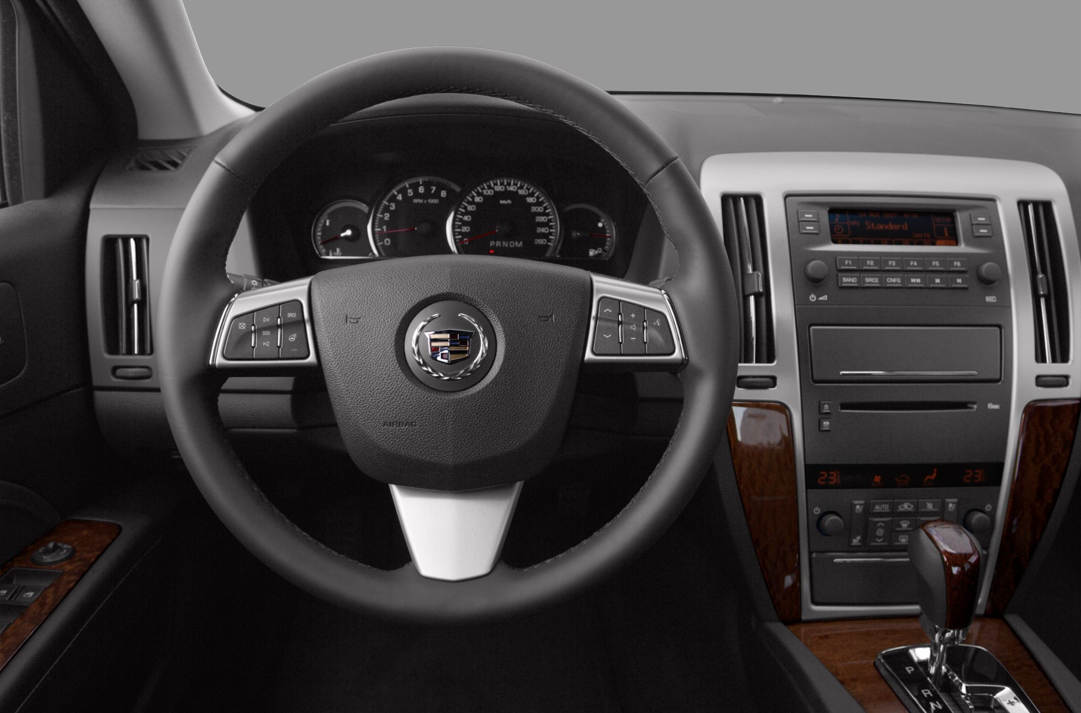 Steering wheel, instrument cluster, center console with gear shifter and wood trim