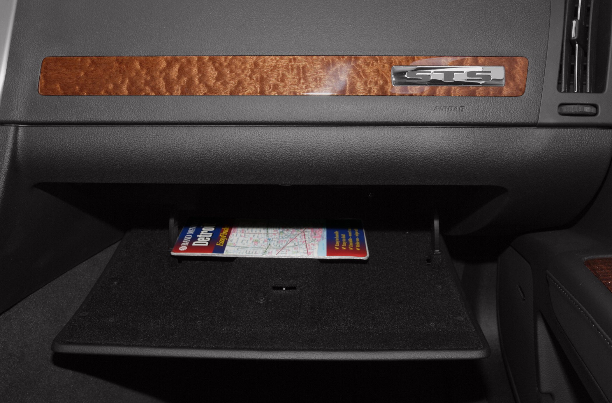 Glove compartment with wooden trim and STS emblem