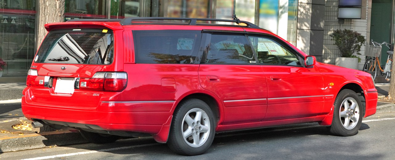 Red station wagon showing rear and side view with alloy wheels