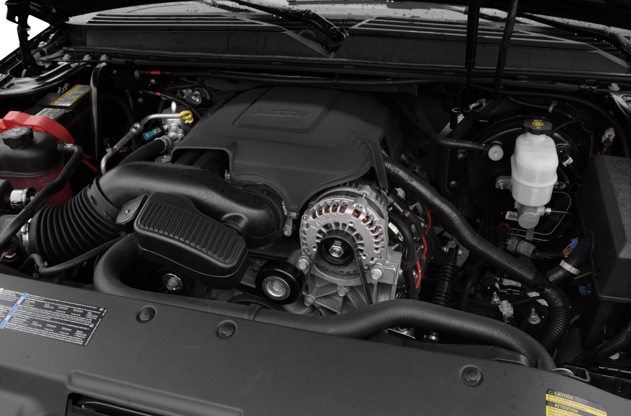 Close-up of engine bay with alternator, air intake system, and fluid reservoirs.