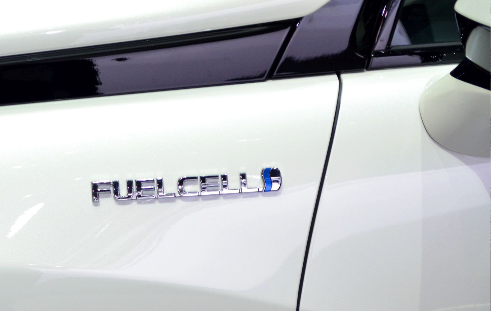 Close-up of fuel cell emblem on vehicle side panel.