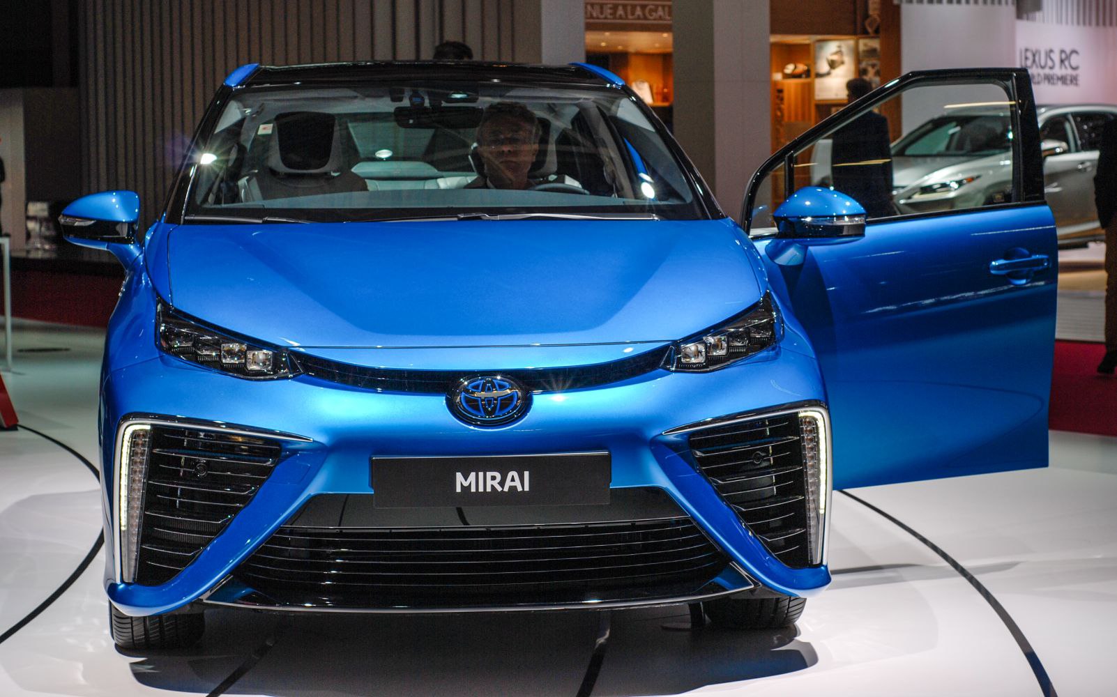 Front view of blue car with open door and LED headlights