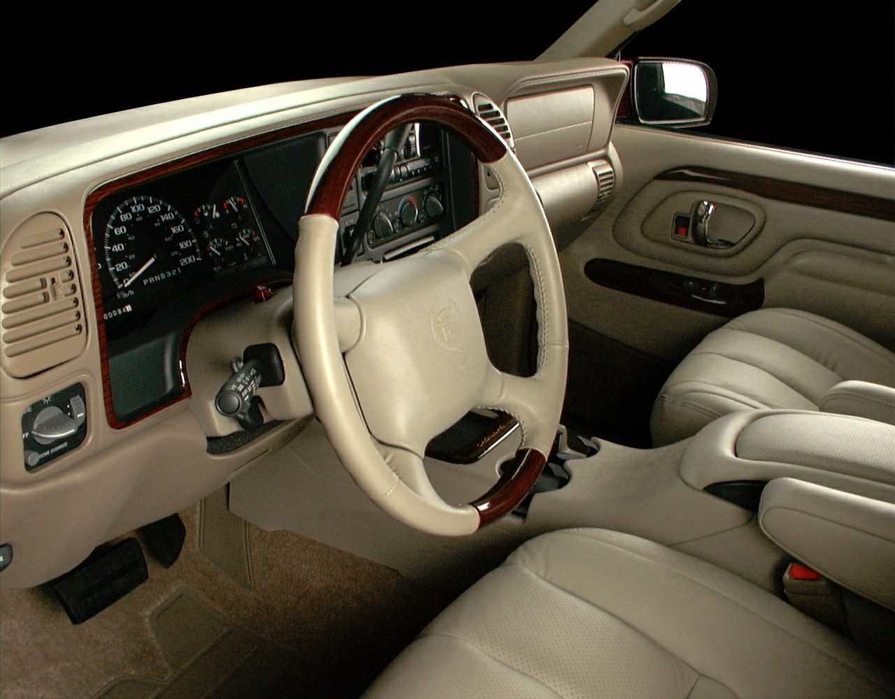 Beige leather interior with wood-trimmed steering wheel and detailed dashboard gauges
