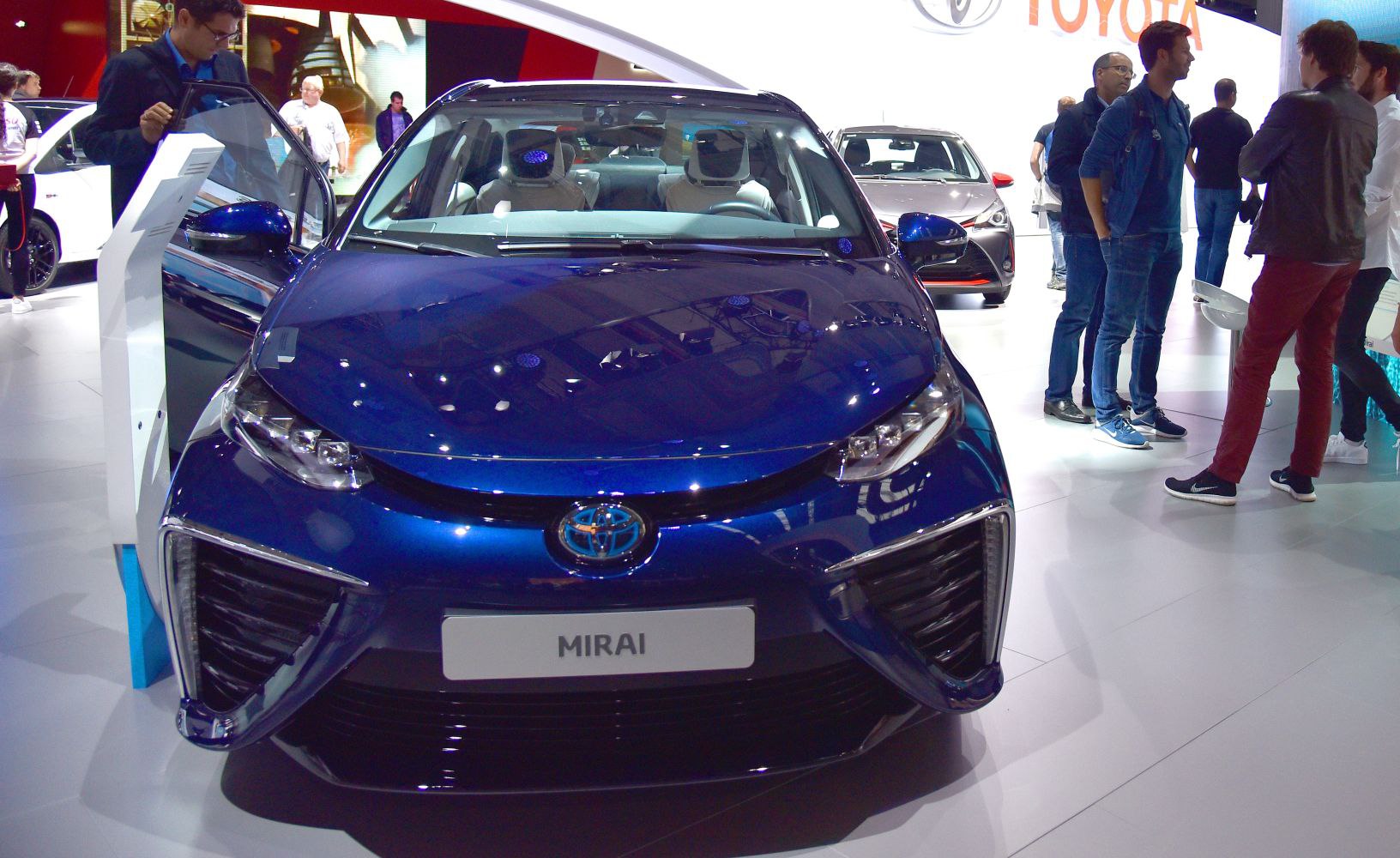 Front view of a blue car with LED headlights and large grille intake
