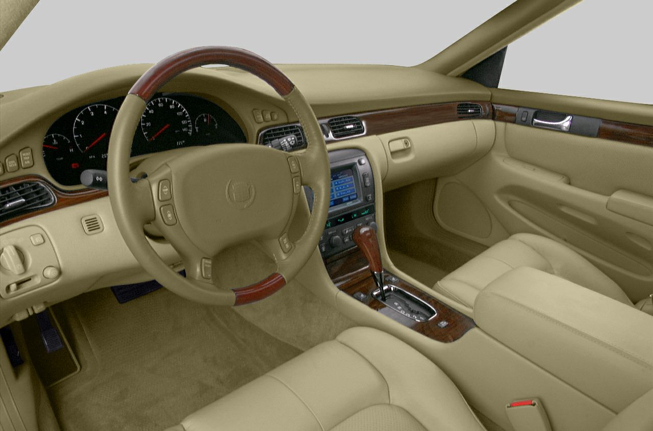 Beige leather interior with wood trim and steering wheel controls.